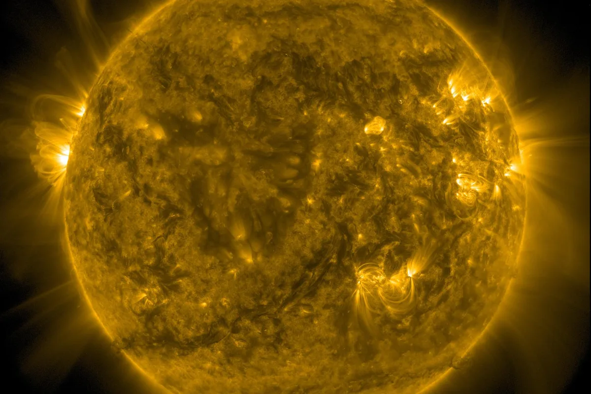 The Sun photographed in extreme ultraviolet light, a mottled orange disc with brighter active regions scattered across its surface.